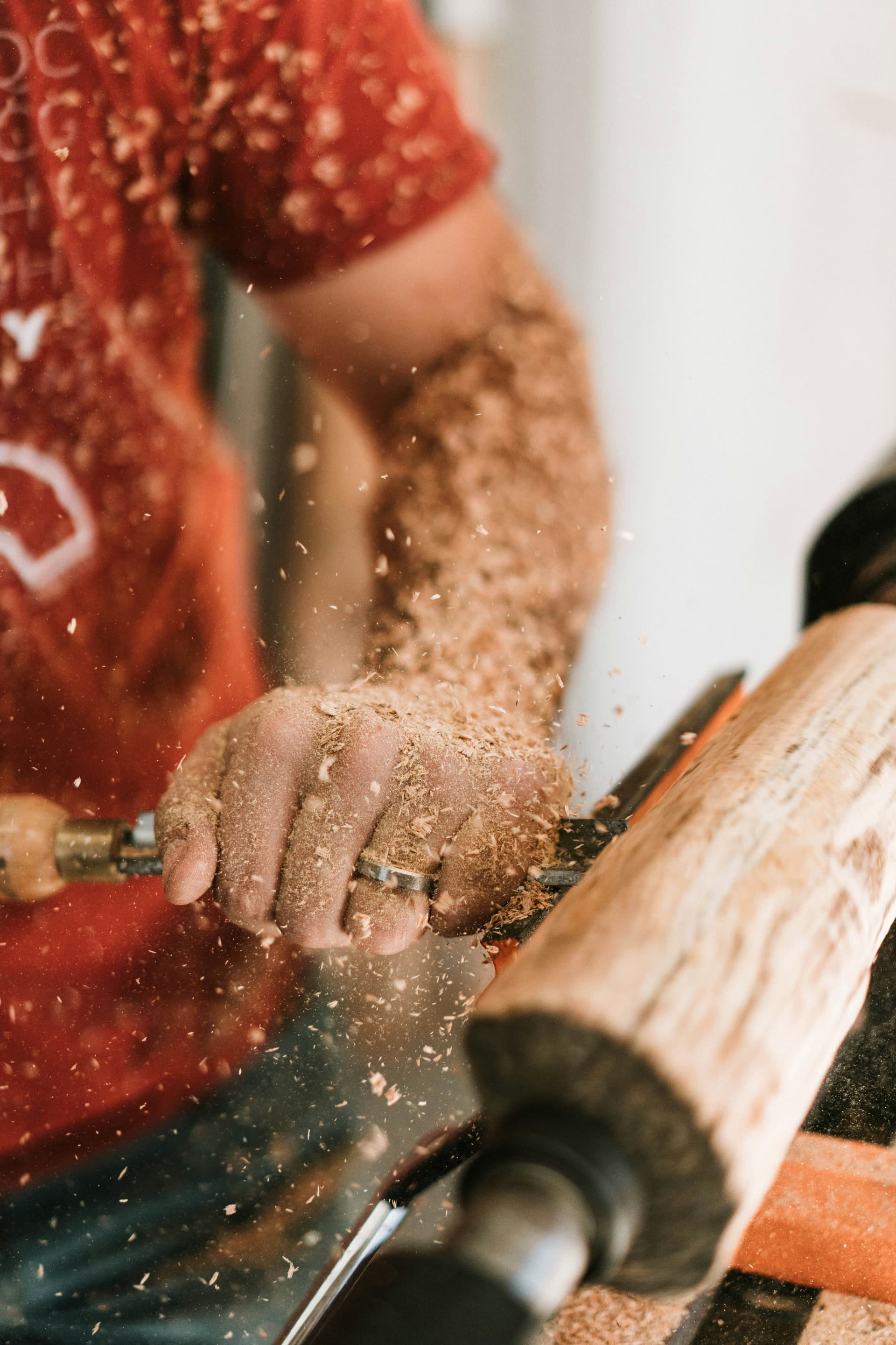 A craftsman shaping a length of teak by hand